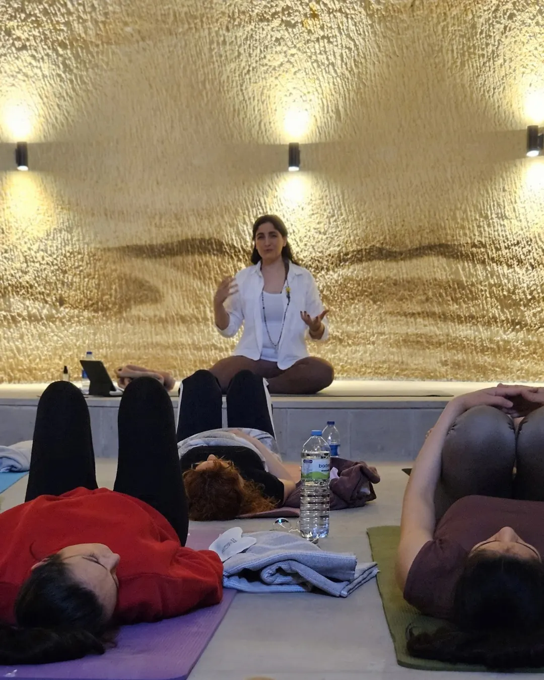Online pratik: Burcu ekranın karşısında, matın üstünde, ev ışığında.